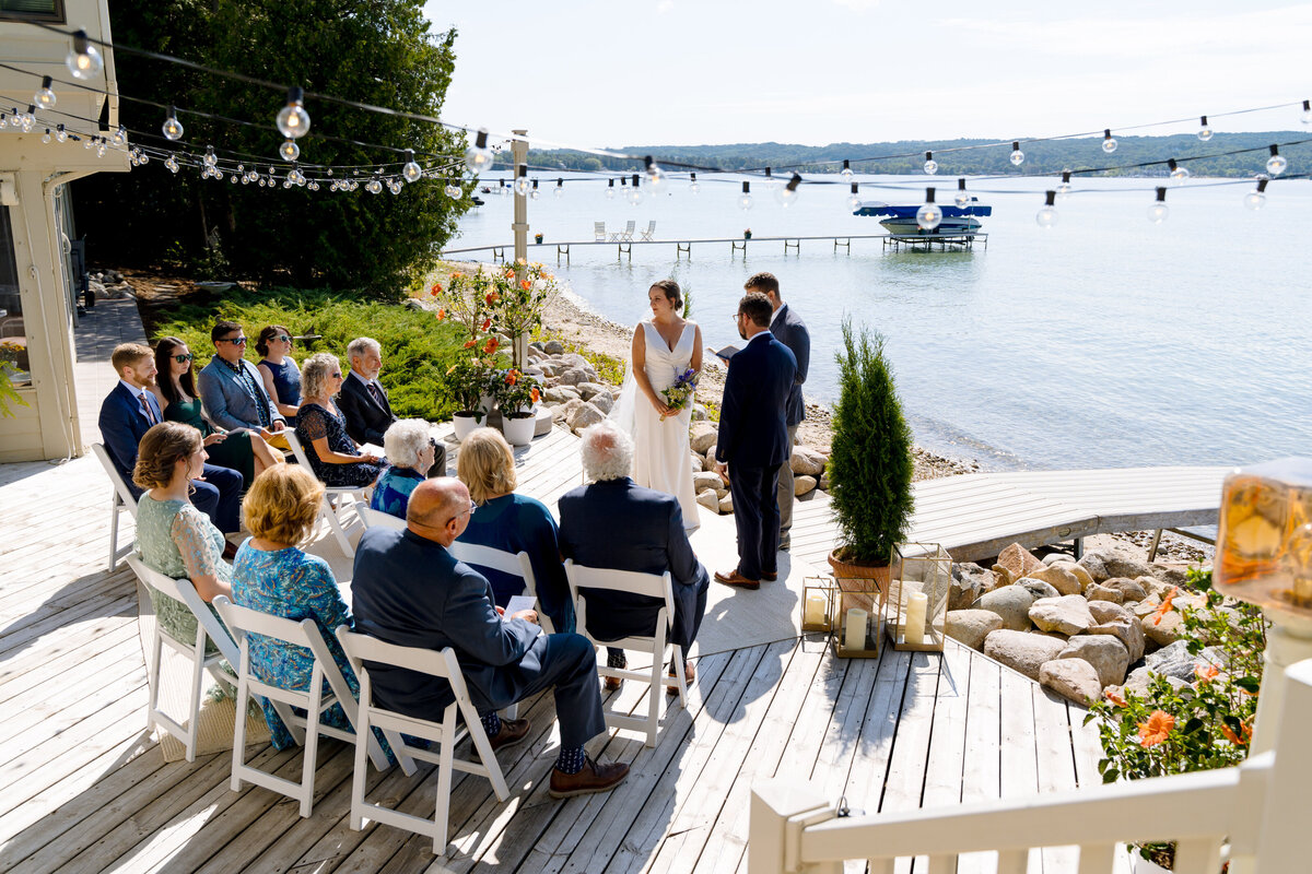A small wedding on a dock in front of the water.