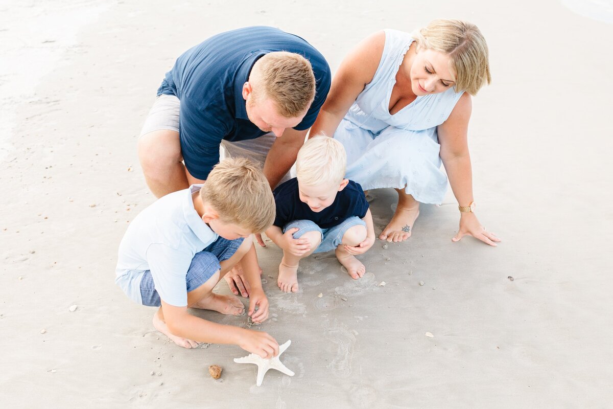 Family finding starfish on the beach