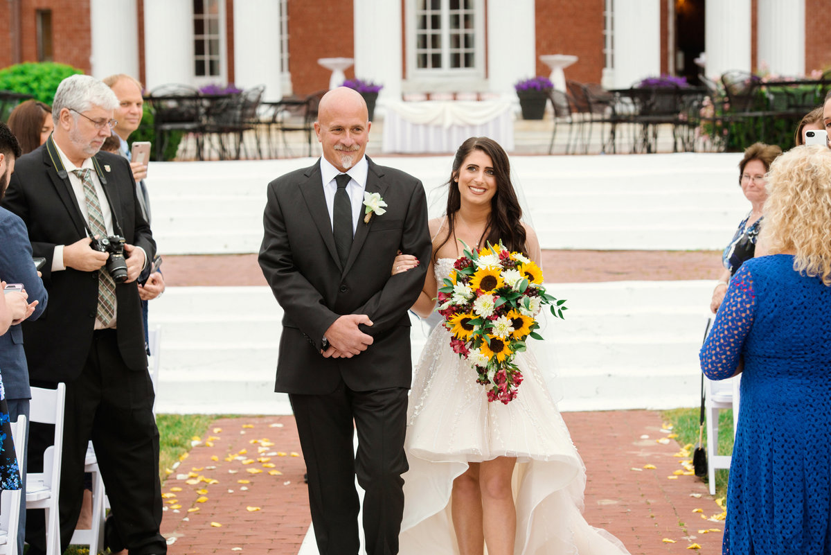 Father walking with his daugther down the asile at awedding ceremony at The Bourne Mansion