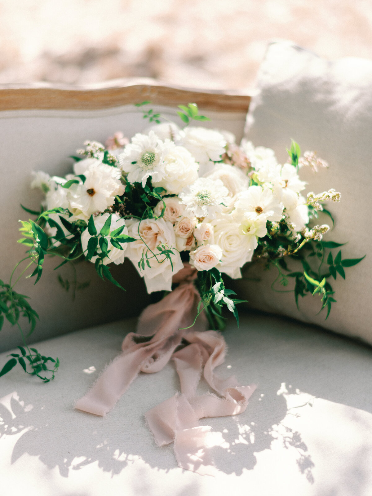vintage bouquet with pink ribbon and white flowers at wedding