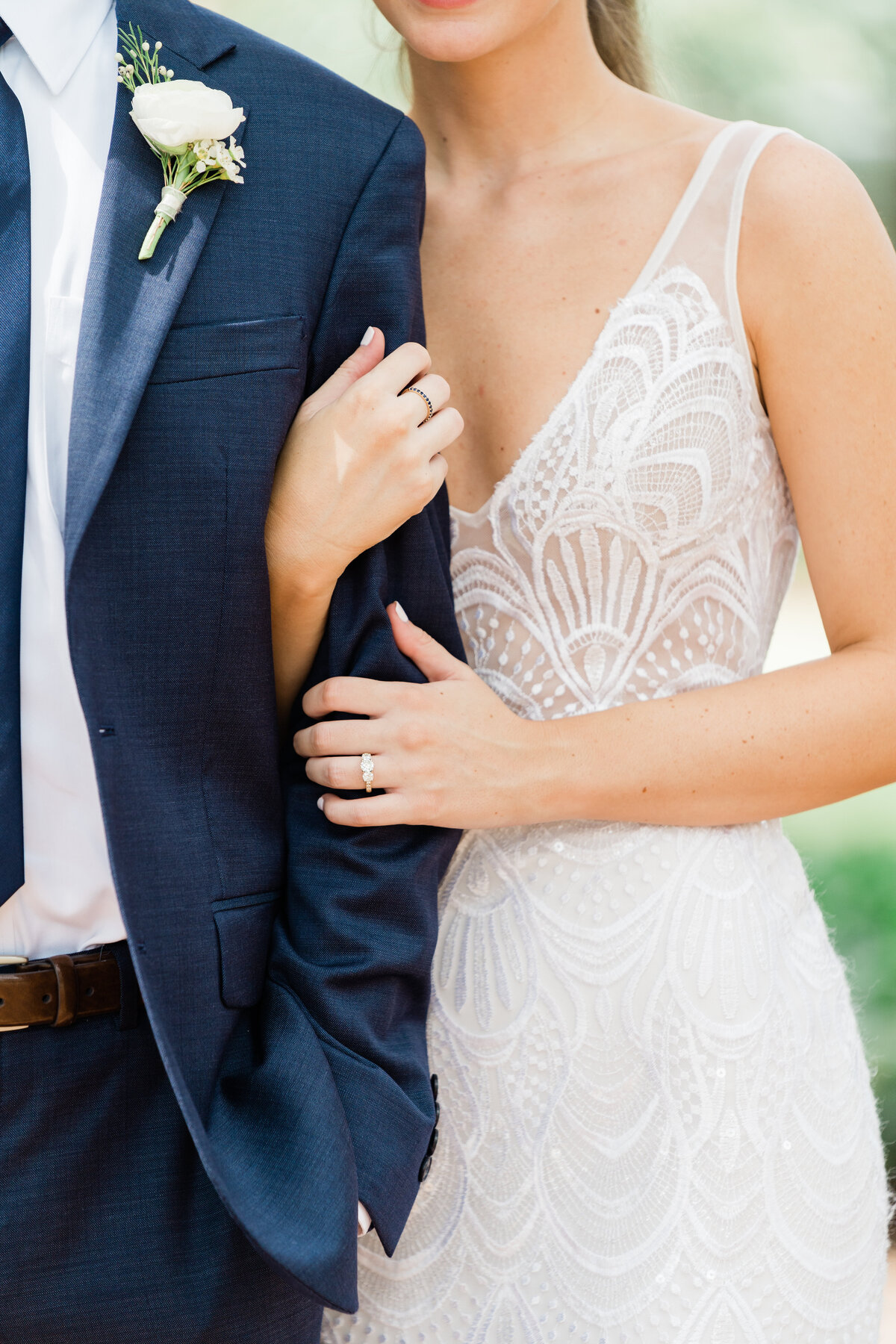 Closeup of bride holding groom's arm