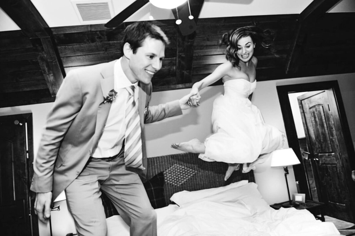 couple jumping in bed after wedding at west shore cafe