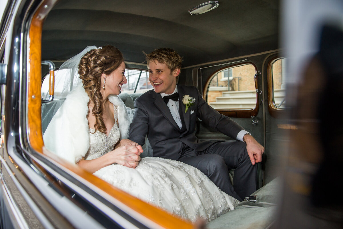 A couple in a vintage car after their  wedding ceremony.