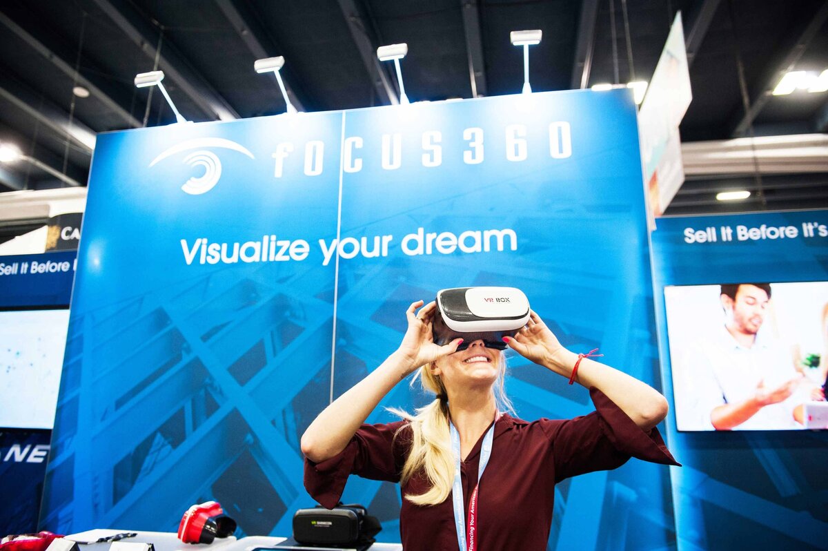Women looks through VR goggles used for virtual home tours at a PCBC homebuilder's conference in San Francisco