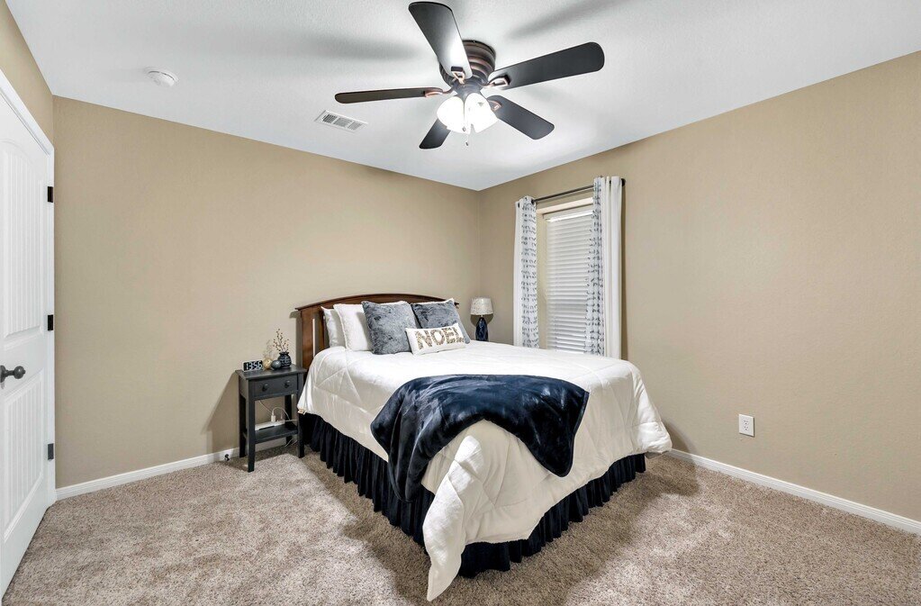 Bedroom with beautiful bedding in this four-bedroom, four-bathroom vacation rental home and guest house with free WiFi, fully equipped kitchen, firepit and room for 10 in Waco, TX.