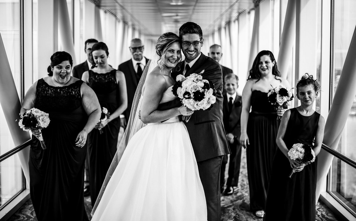 Bride and groom pose with their bridal party on the skybridge at Sheraton Erie Bayfront Hotel