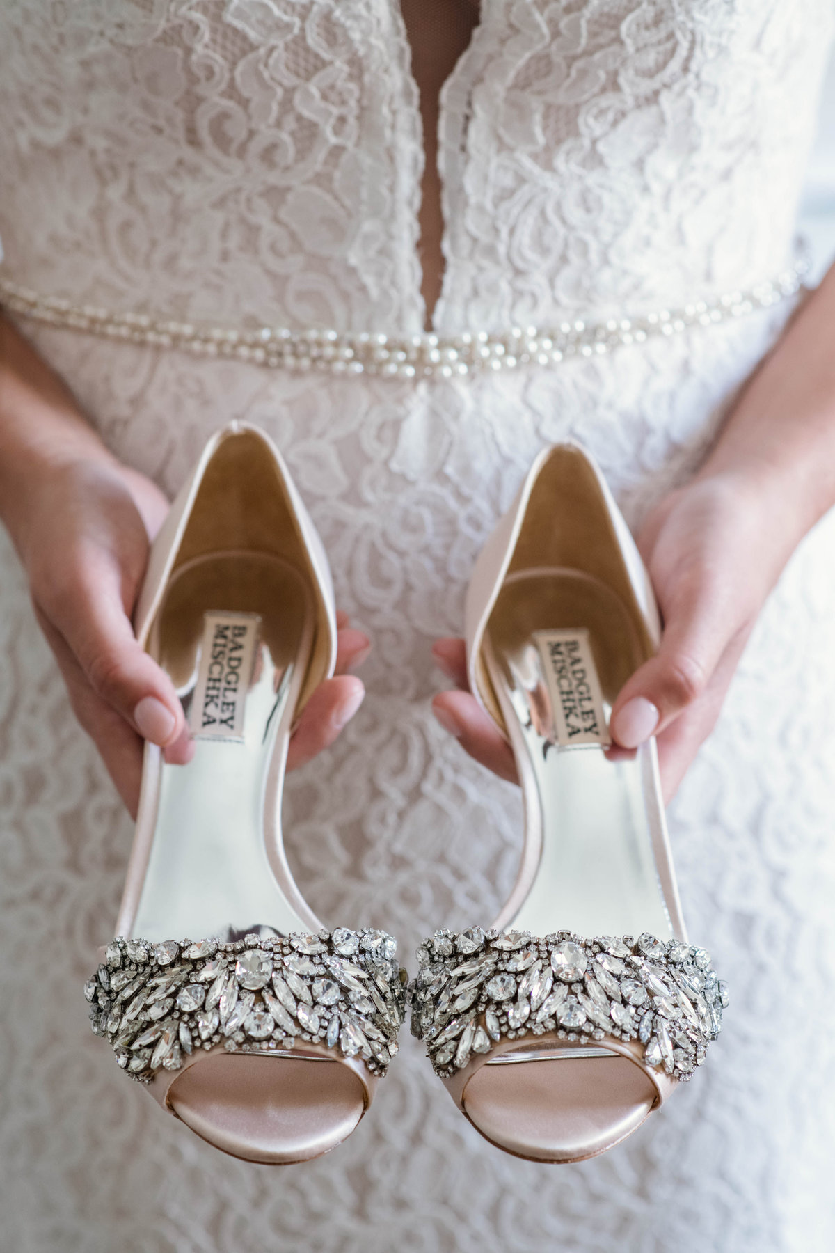 photo of bride holding wedding shoes from wedding at the Mansion at Timber Point