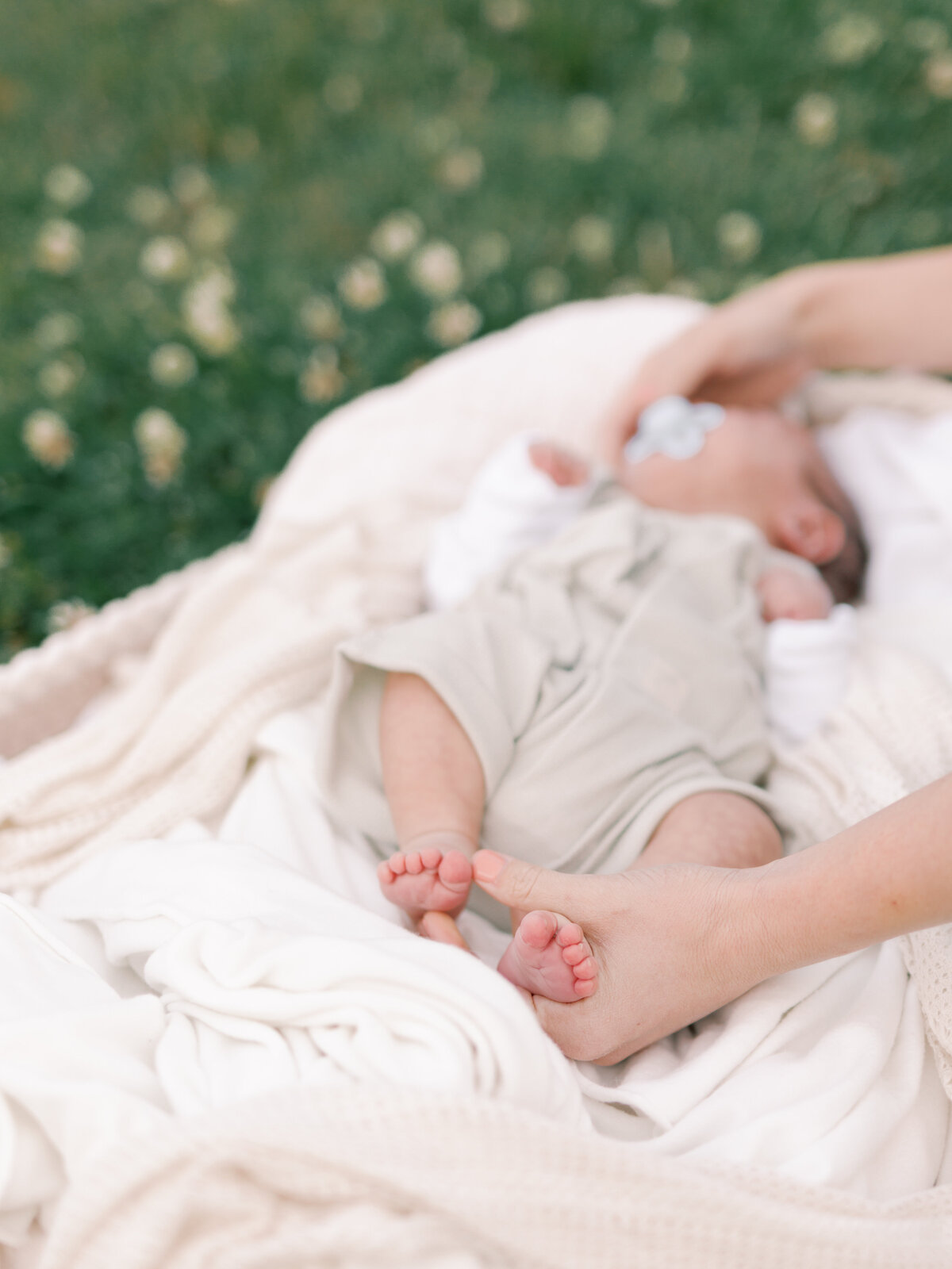 Outdoor newborn session, closeup of mom holding baby's feet by Virginia Photographers
