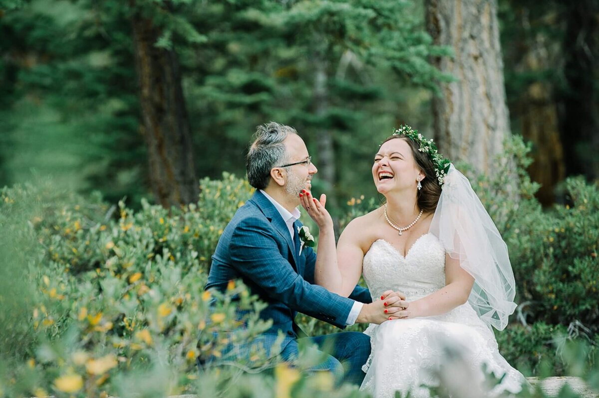 couple sitting and being playful during portraits in the woods in Lake Tahoe