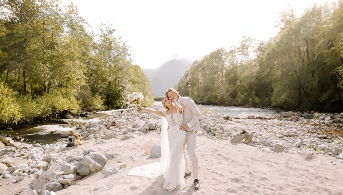 wedding couple standing in rocks near river