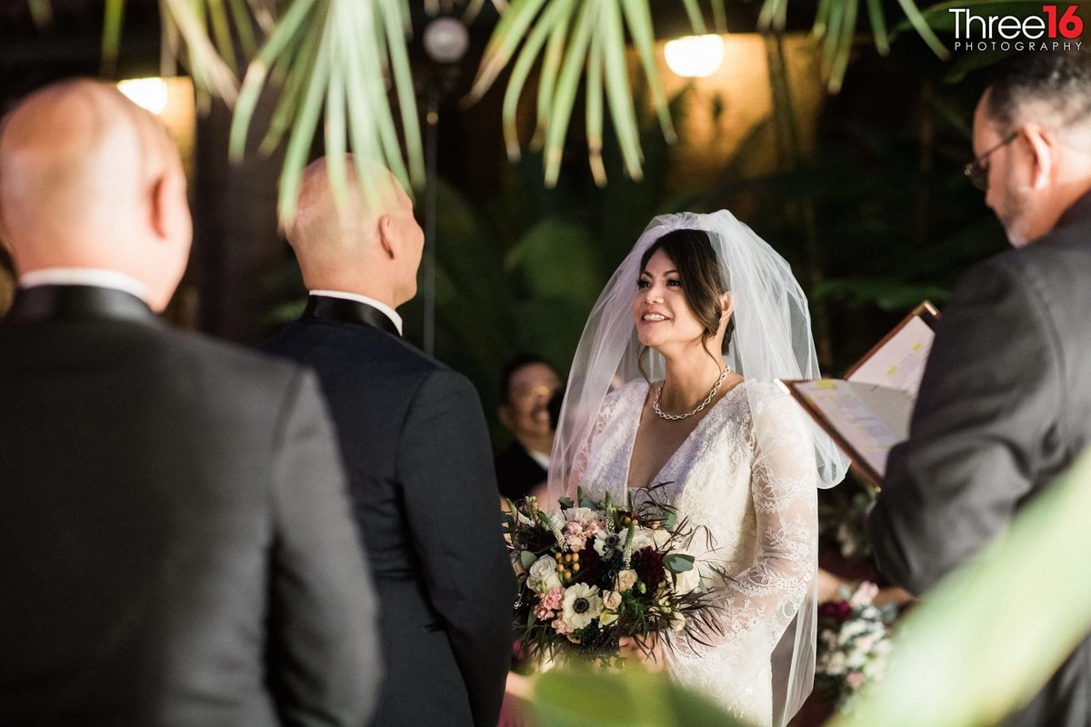 Bride smiles at her Groom during the wedding ceremony