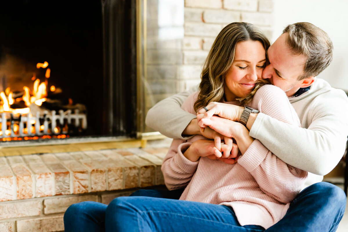 Man and woman hug next to fire during a couples session in Naperville, IL.
