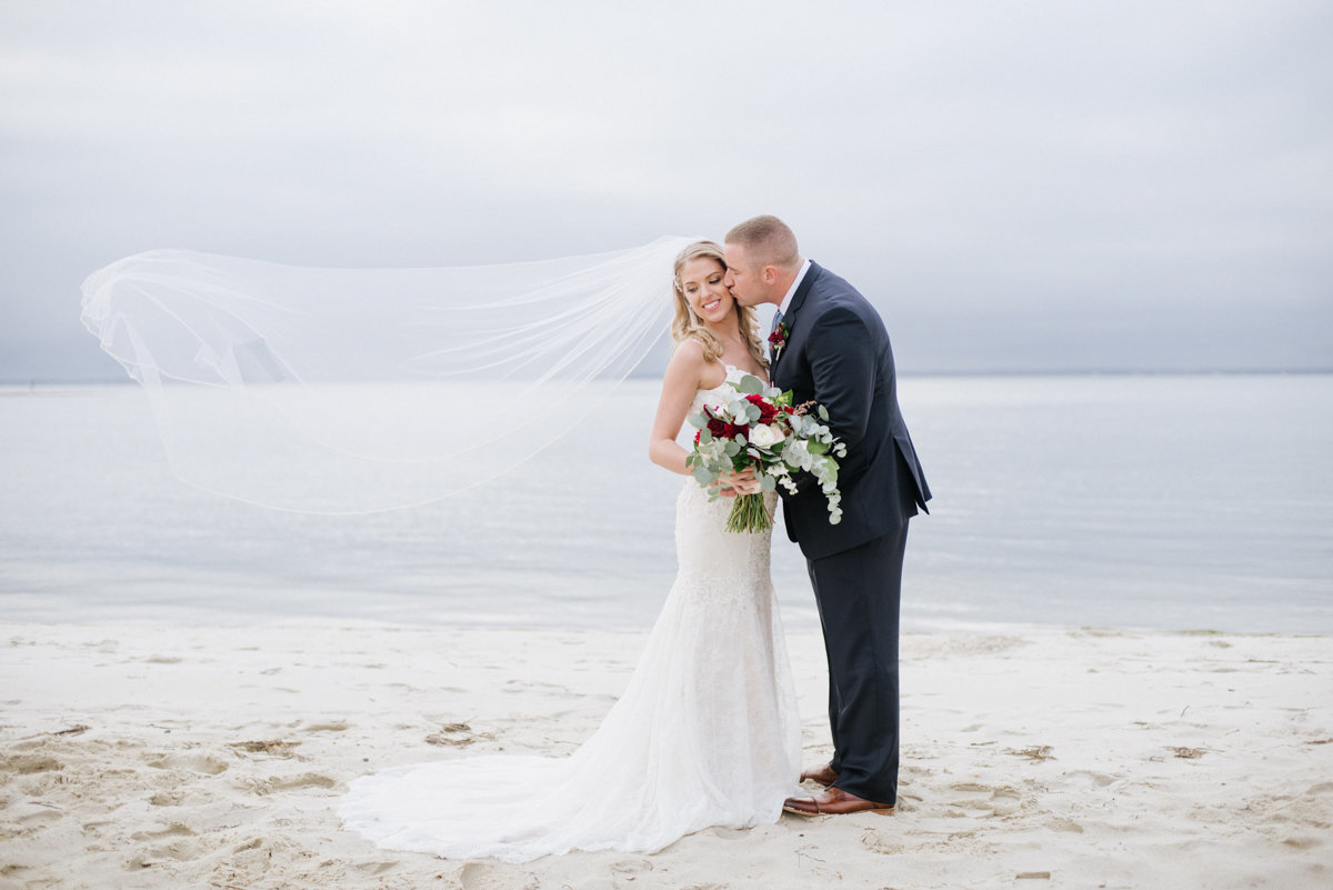 wedding photo on beach with cathedral veil