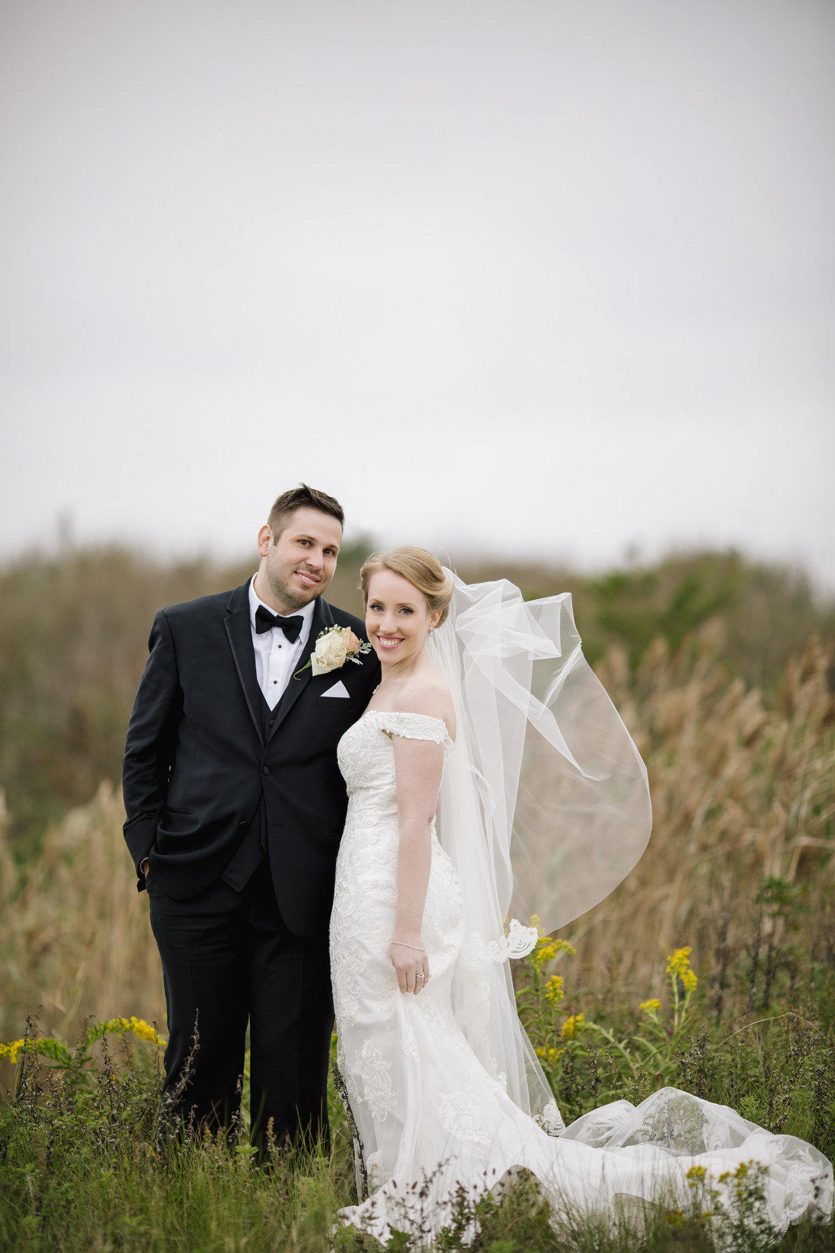 bride and groom in tall grass at  spring lake wedding