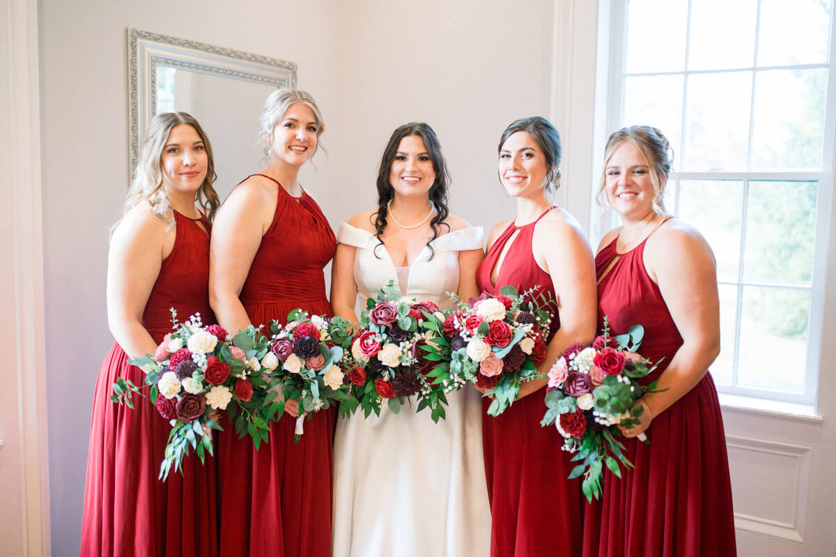 Bridesmaids in red dress holding flowers