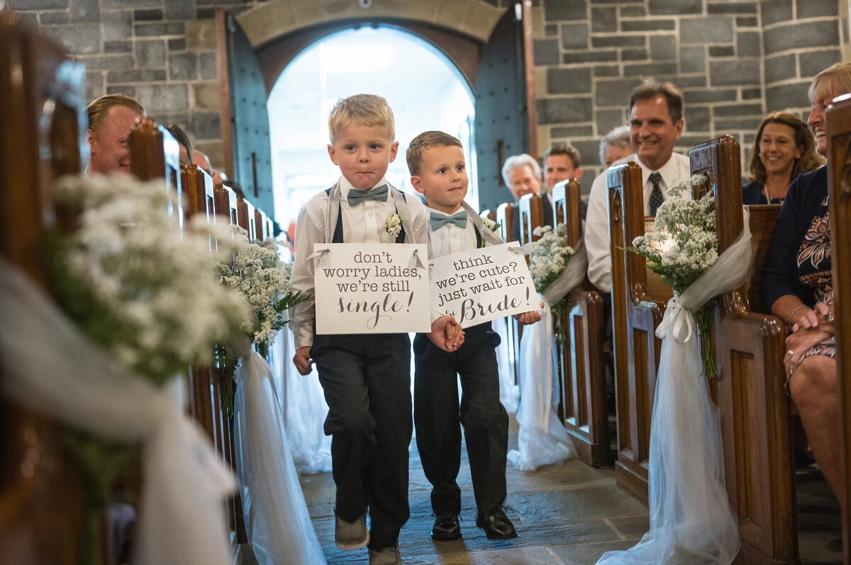 Ring bearers carrying signs during ceremony.