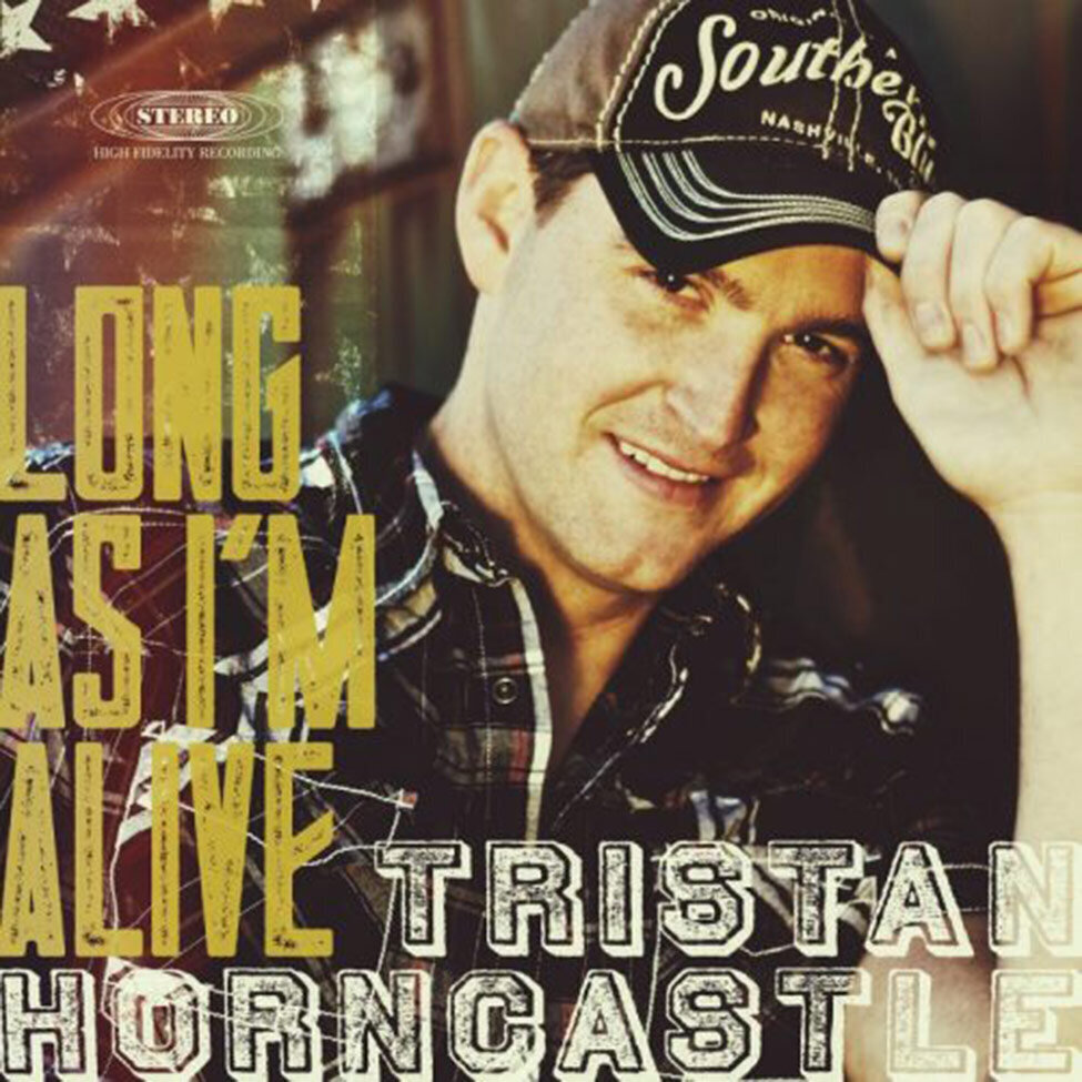 CD Single Cover Title Long As Im Alive Country Music Artist Tristan Horncastle standing next to rusted old trailer hand on brim of baseball cap