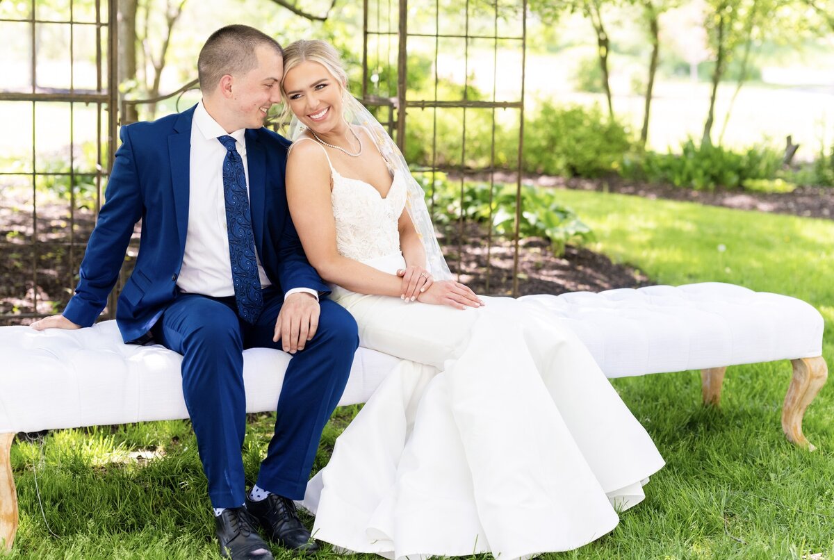 bride and groom sitting on bench