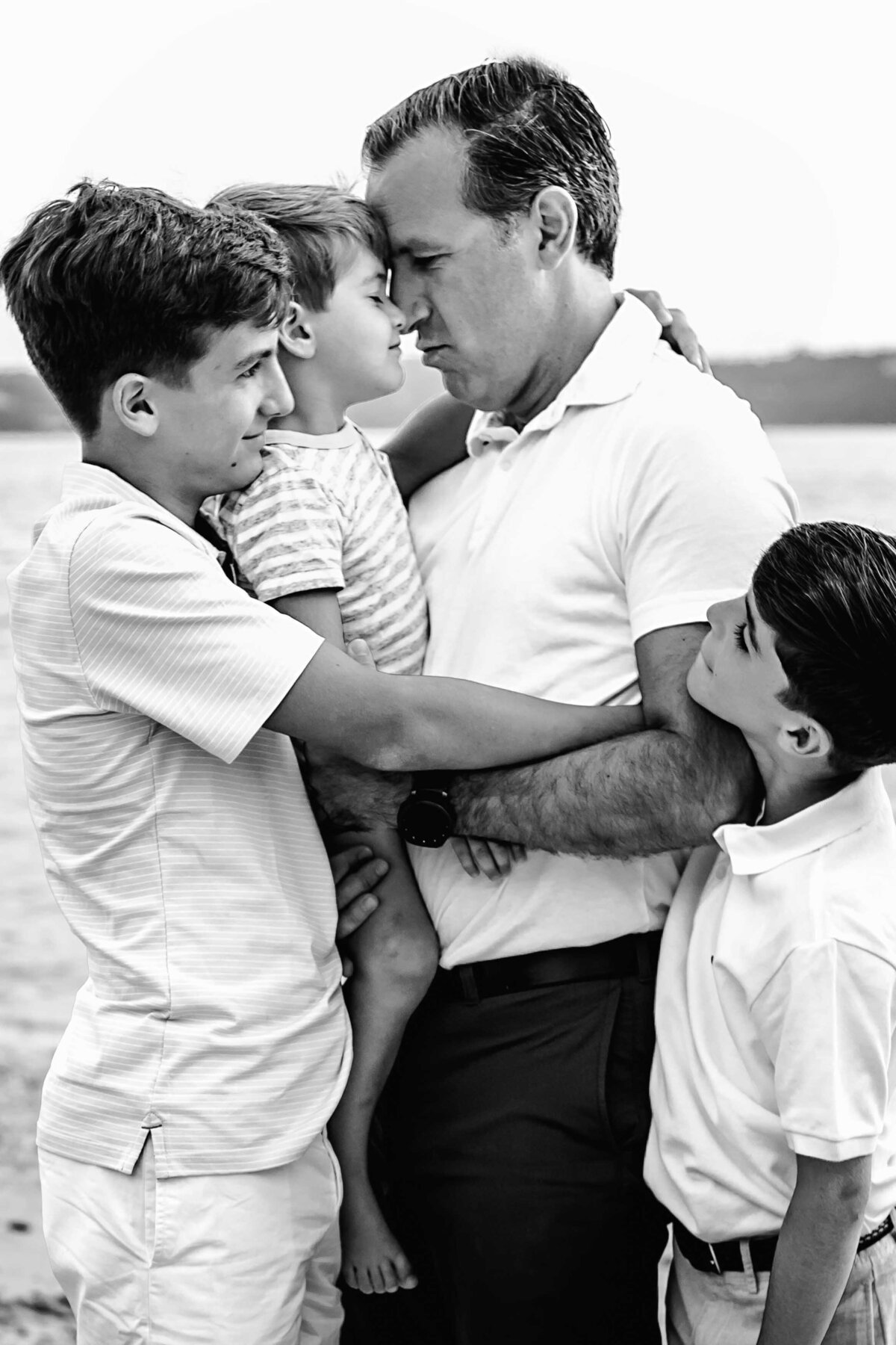 father with sons during beach photo session on long island