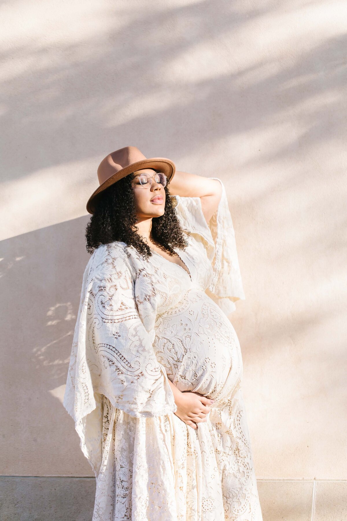 pregnant woman with hat on  with closed eyes basking in sun