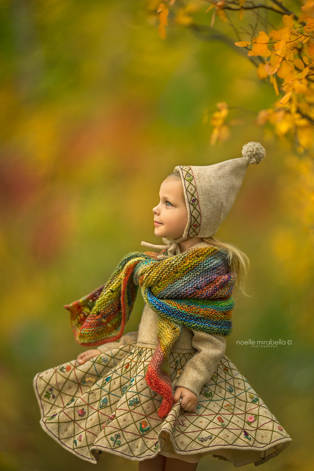Girl twirling in hand embroidered Harris Tweed dress in autumn.