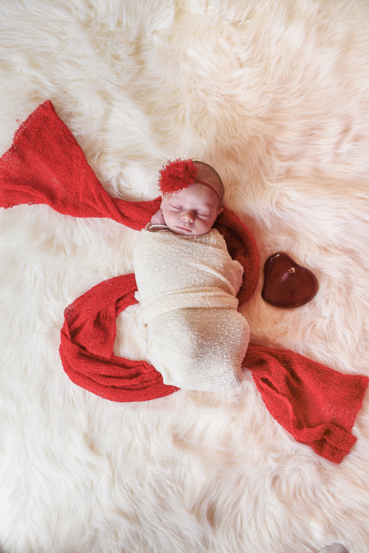 Beautiful Mississippi newborn photography: newborn girl red with a red glass Tiffany heart for Valentines in Mississippi