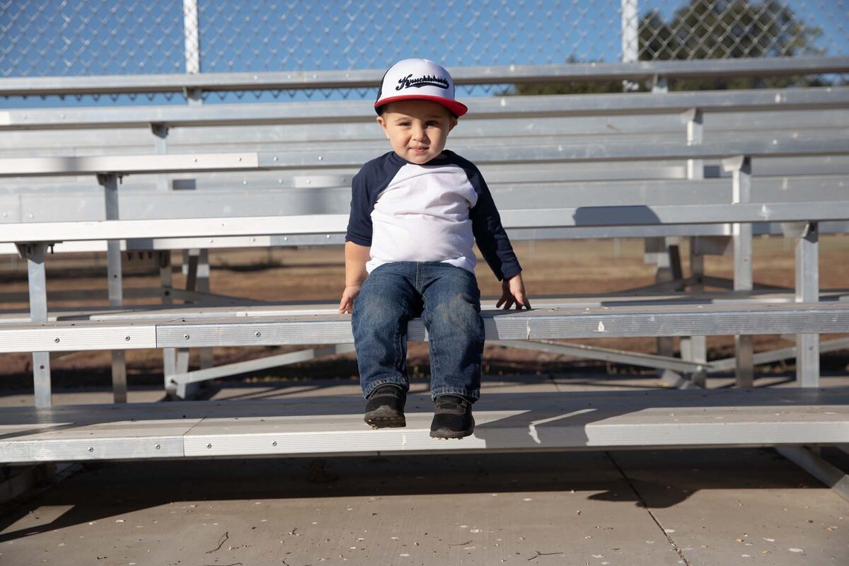 little boy on baseball bleachers