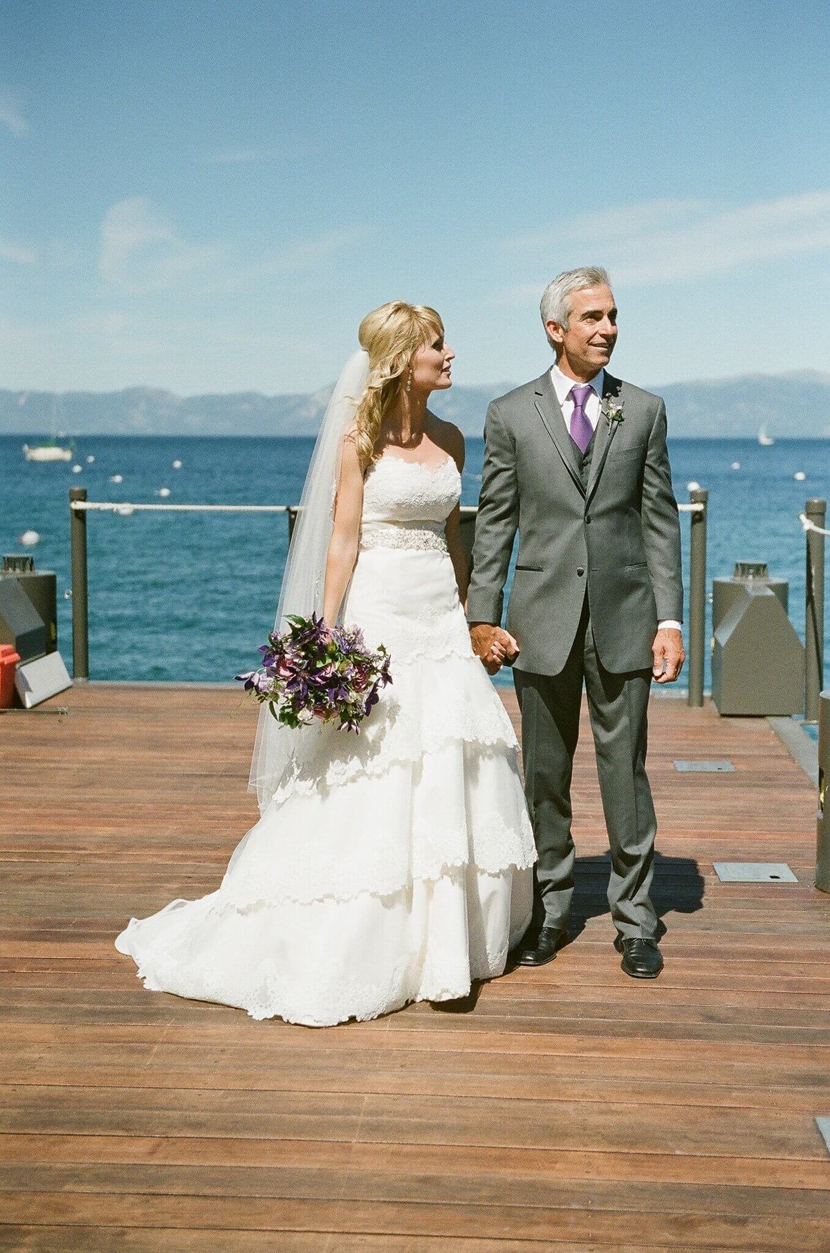 bride and groom on pier at west shore cafe in lake tahoe