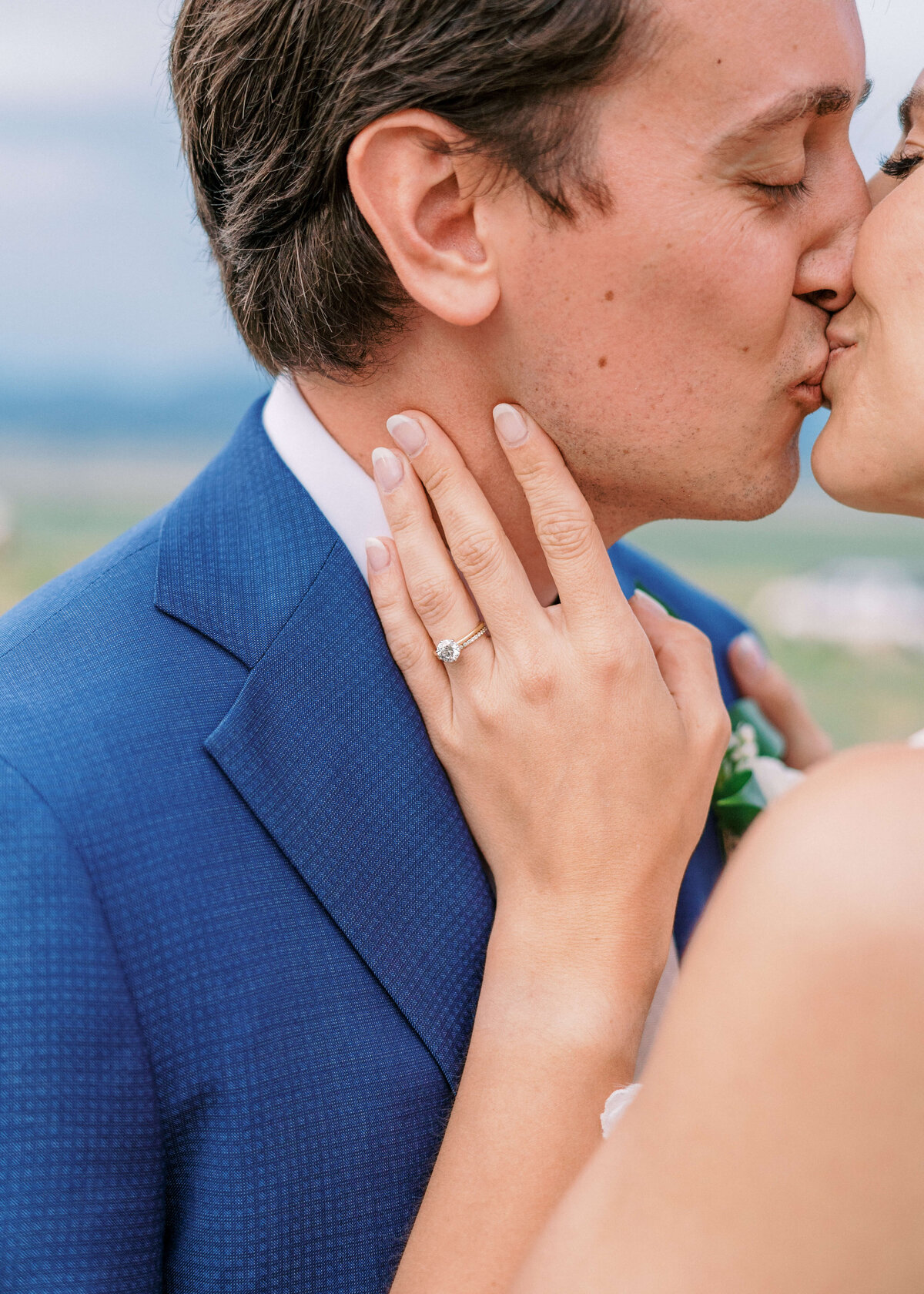 Bride shows off her ring while kissing her new husband