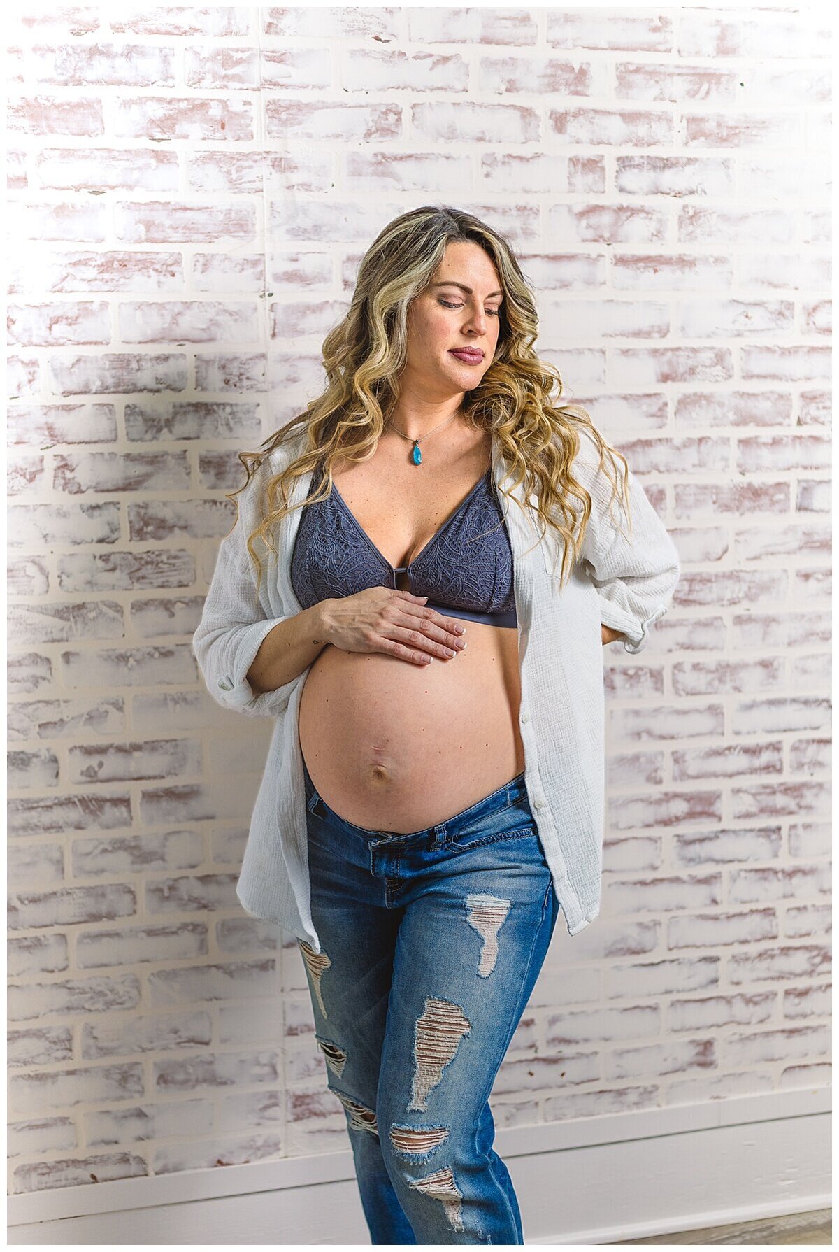 Mom to be showing off her beautiful baby bump in a cute top and jeans during a maternity photoshoot in studio in Wexford PA