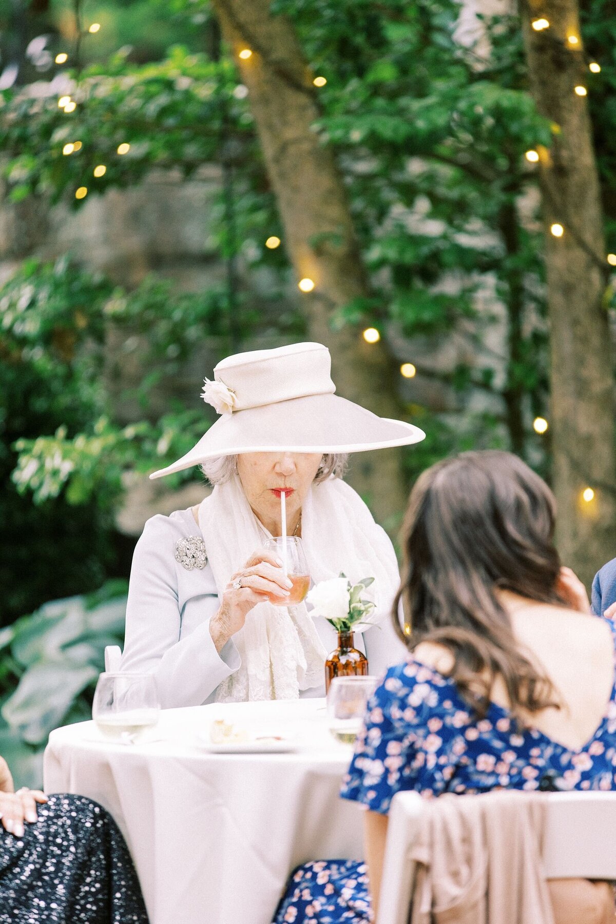 Wedding guest sipping a drink during cocktail hour