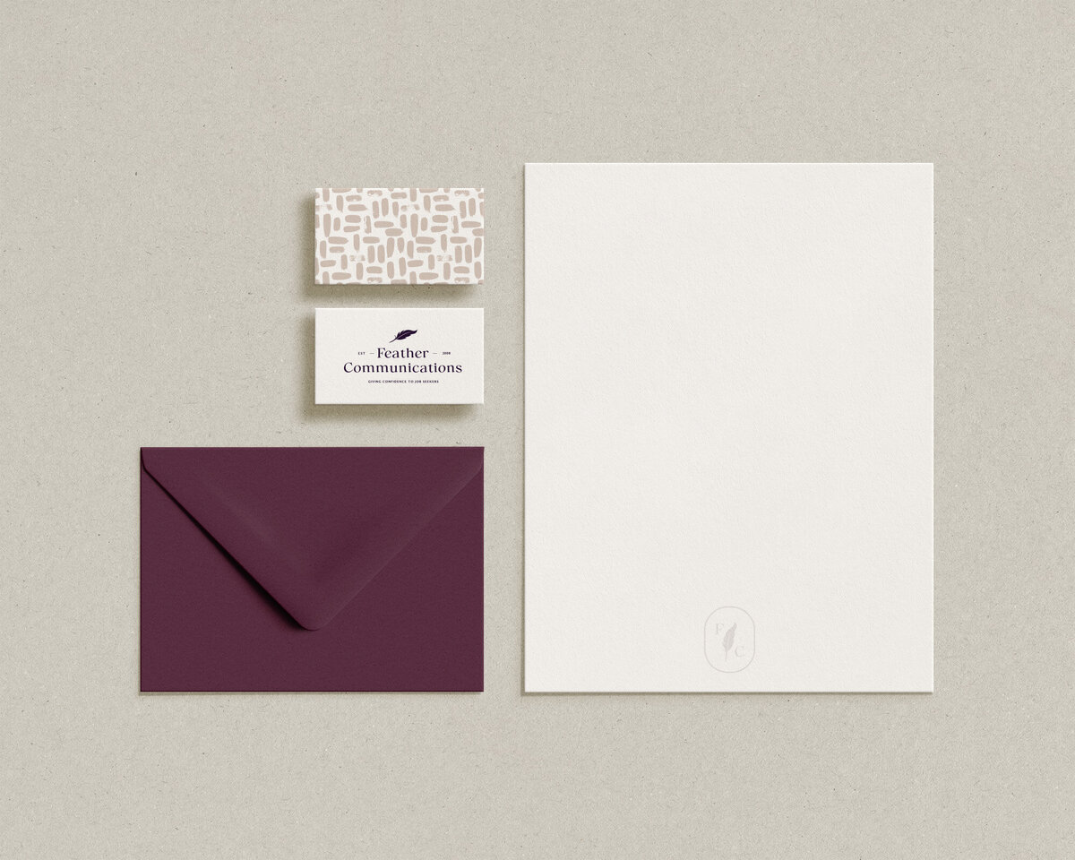 Deep purple envelope sitting next to branded business cards and letterhead