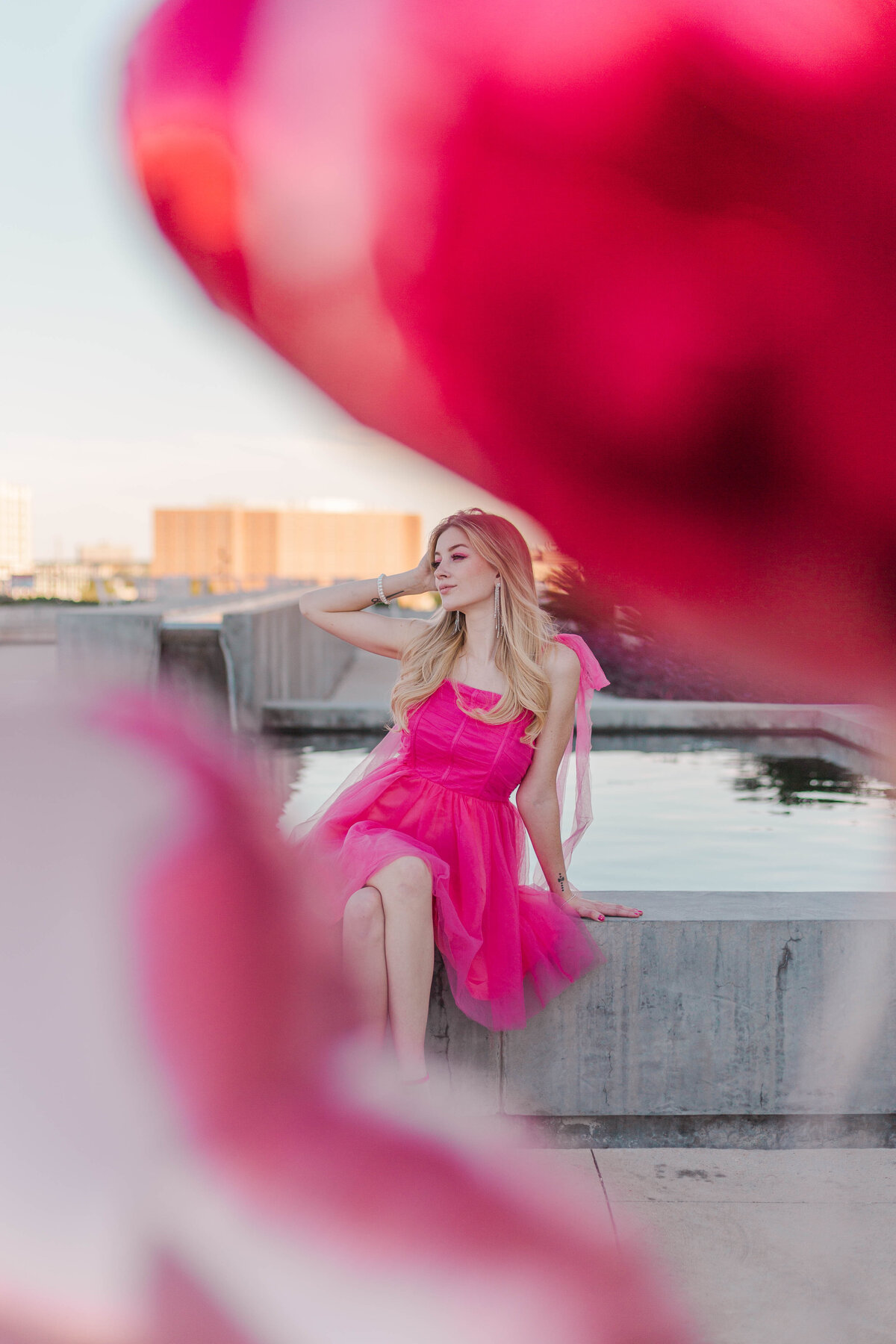 barbie model on post houston rooftop framed by two heart-shaped balloons