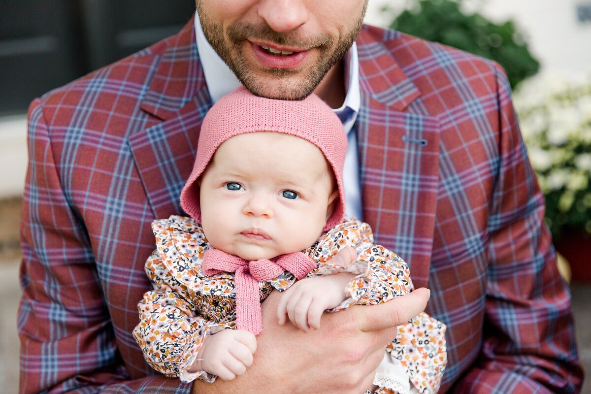 A bearded dad in a plaid jacket snuggling his newborn daughter during an in-home newborn session in Lexington KY.