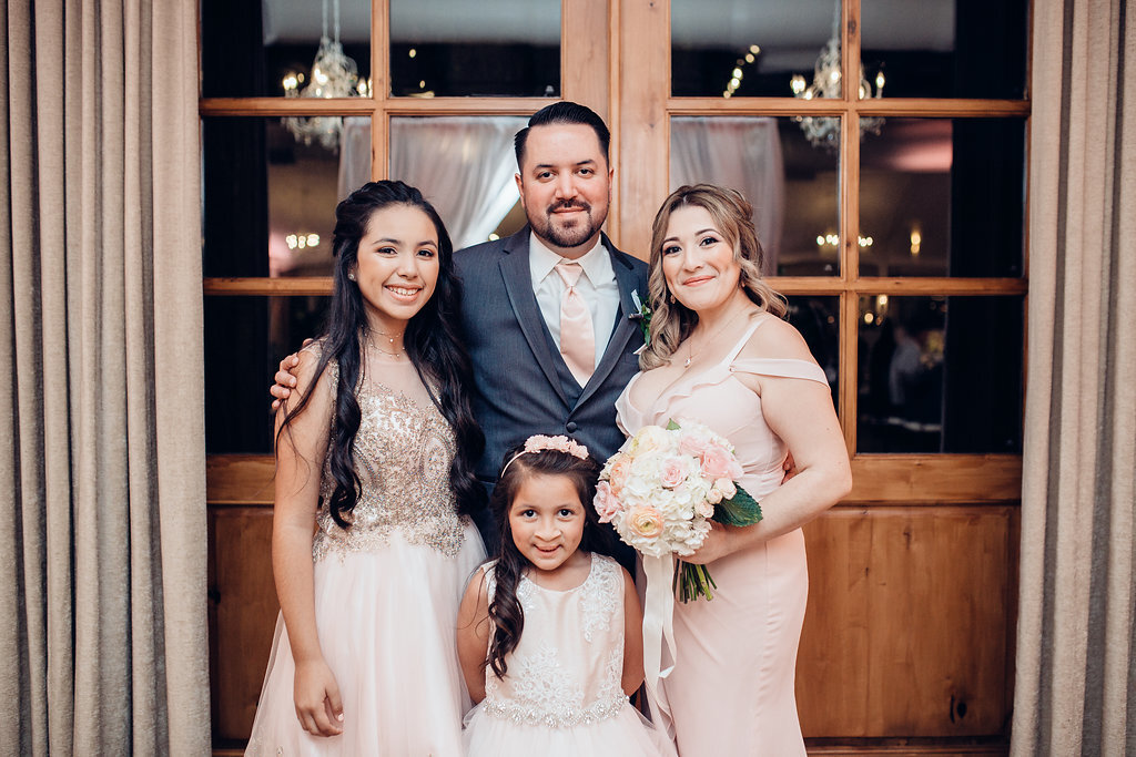 Wedding Photograph Of Man In Suit Beside a Woman Carrying a Bouquet And Two Girls Los Angeles
