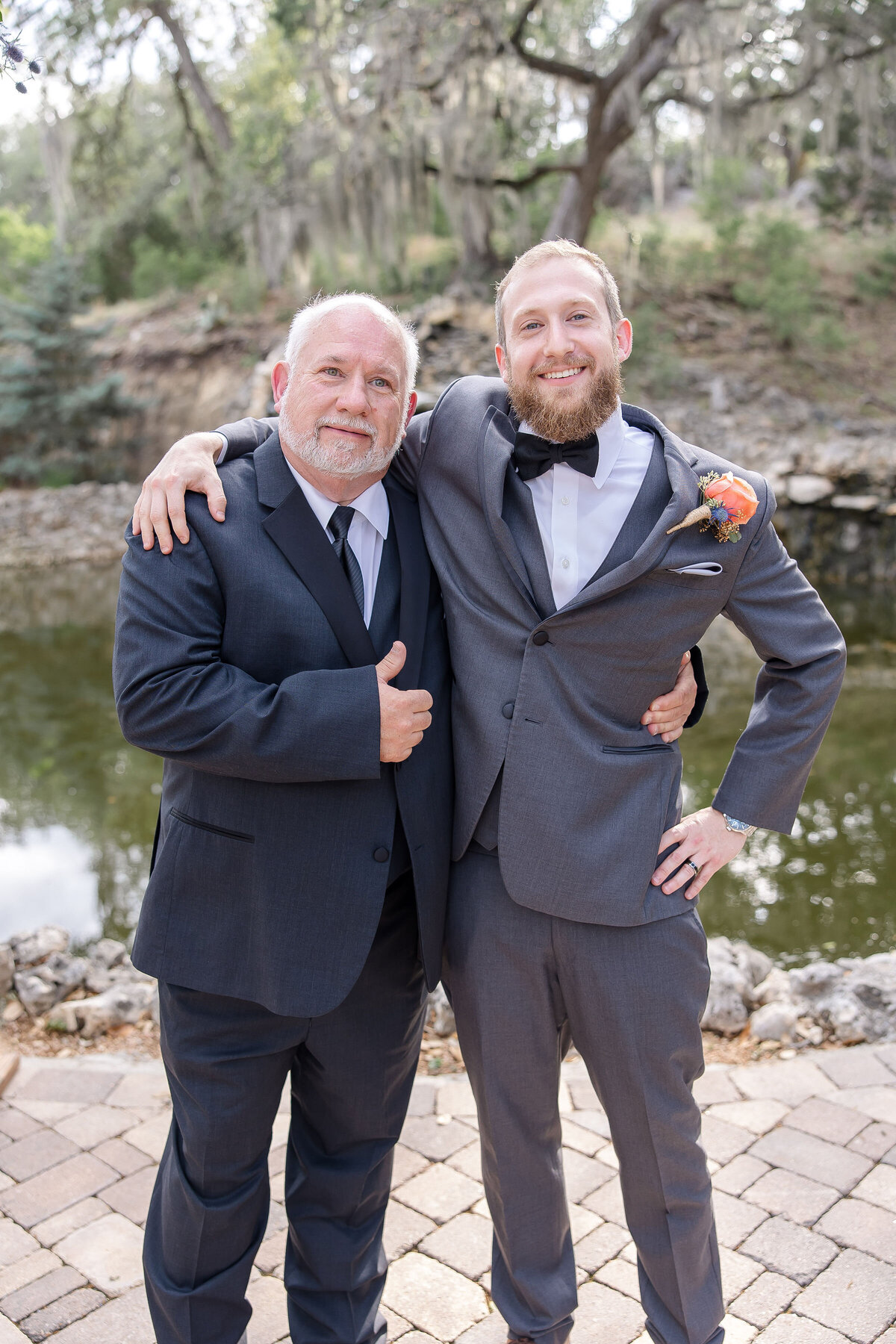 groom and father of groom hug and give thumbs up at Hayes Hollow at Hidden Falls wedding in Spring Branch Texas