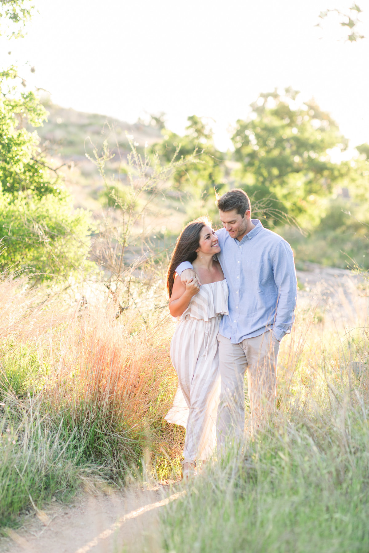 Engagement photos of couple walking at Enchanted Rock; Fredricksburg, Texas