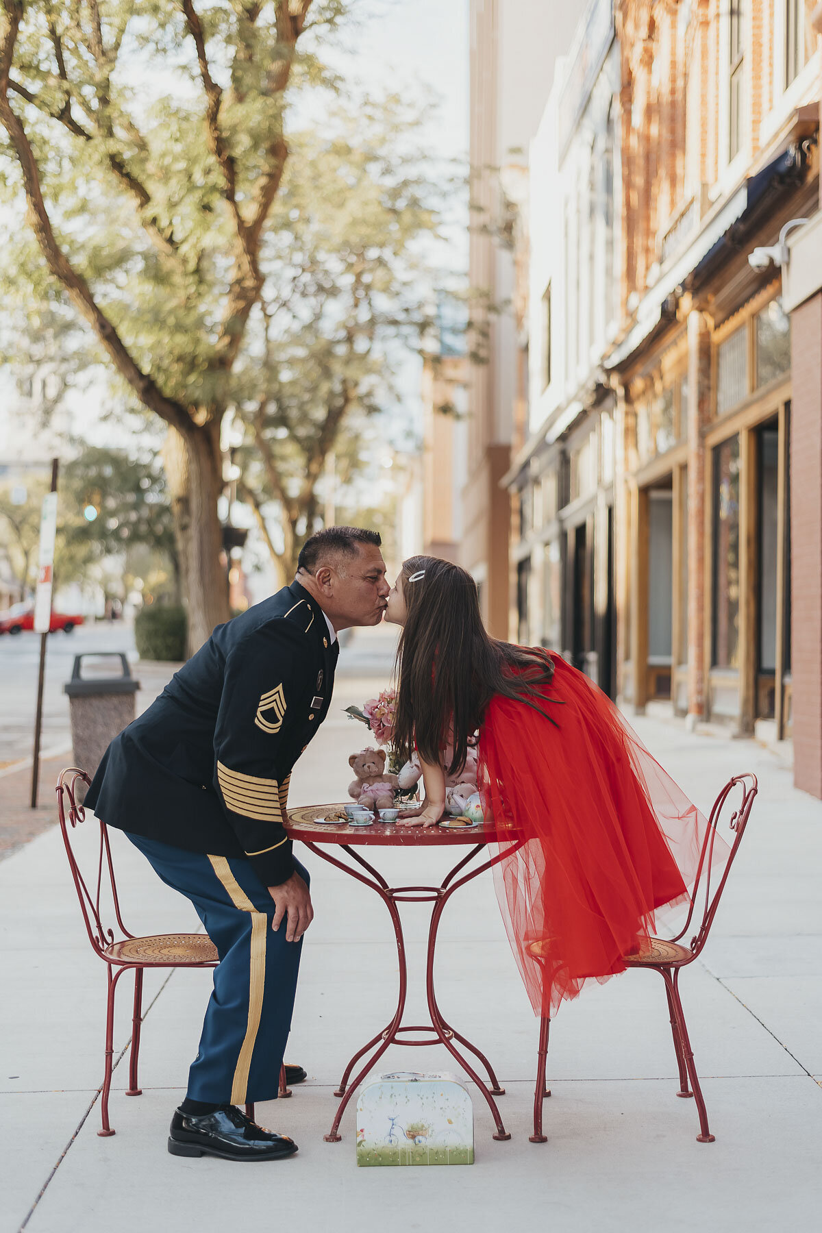 dad in military uniform kissing daughter on father daughter date