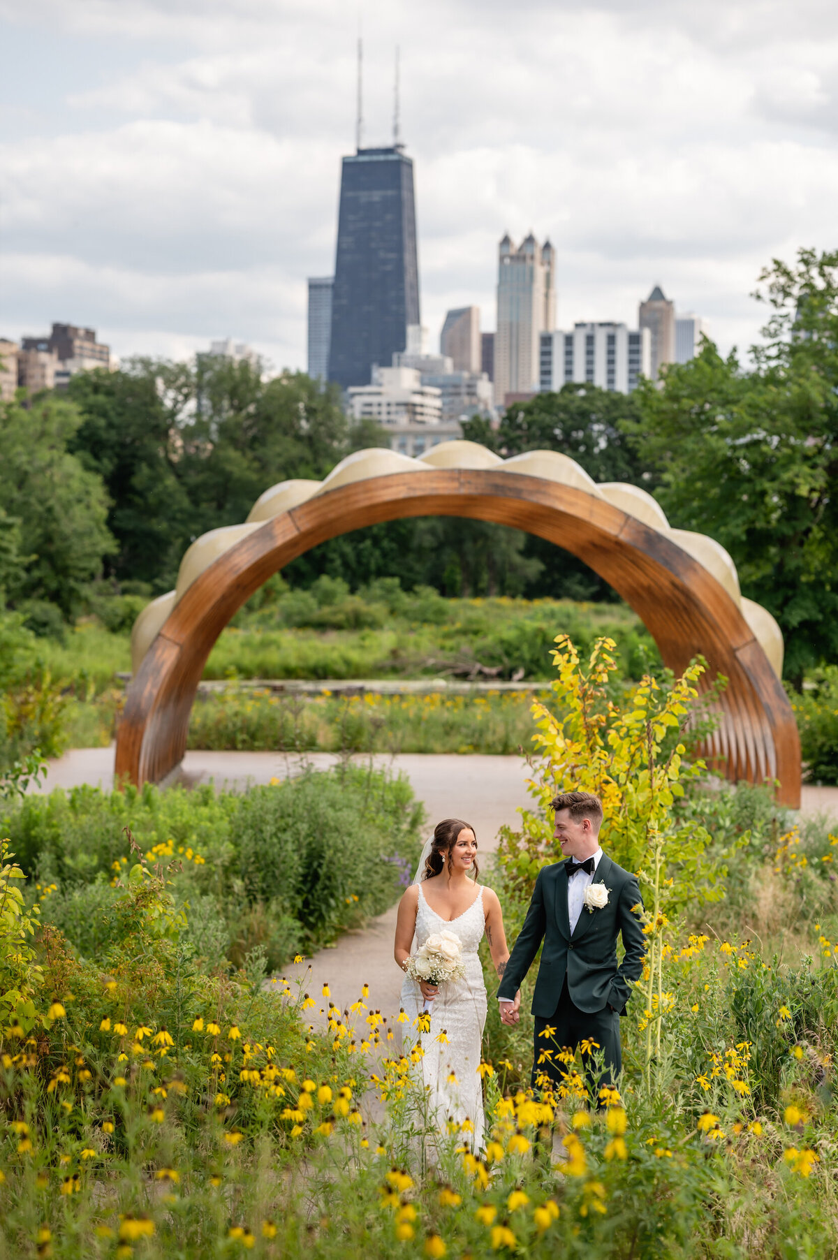 Bride and groom walk in a field of wildflowers in Lincoln Park Chicago, Illinois