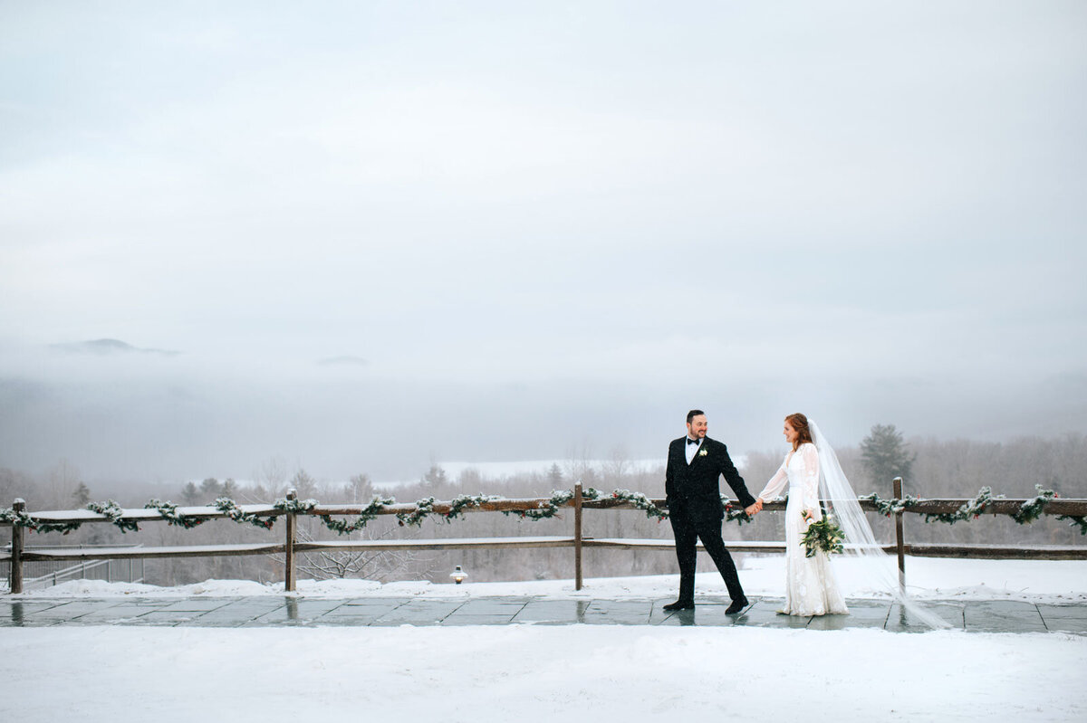 couple walking in snow at mountain top inn in chittenden vermont at elopement