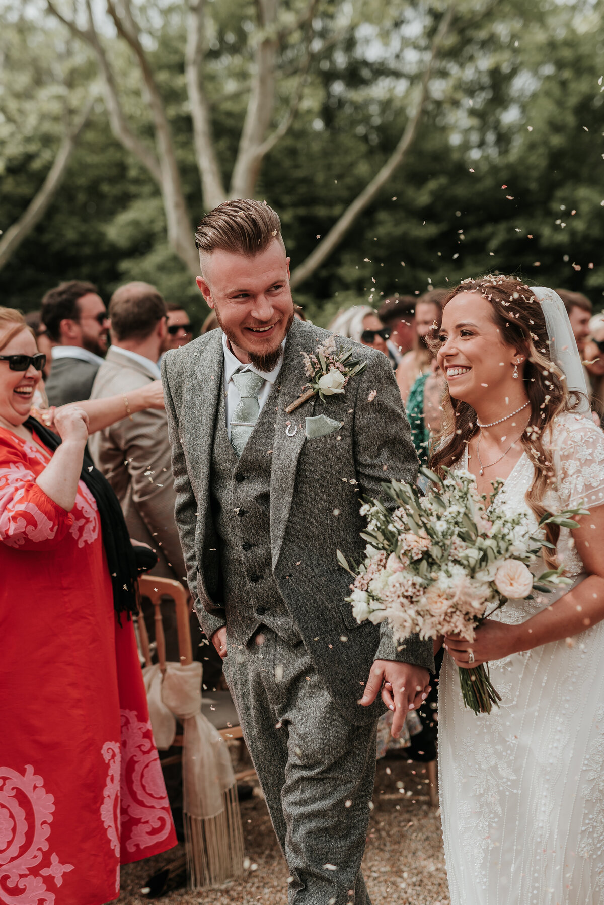 Smiling Bride & Groom showered with confetti at their relaxed spring wedding at Bury Court Barn, Farnham