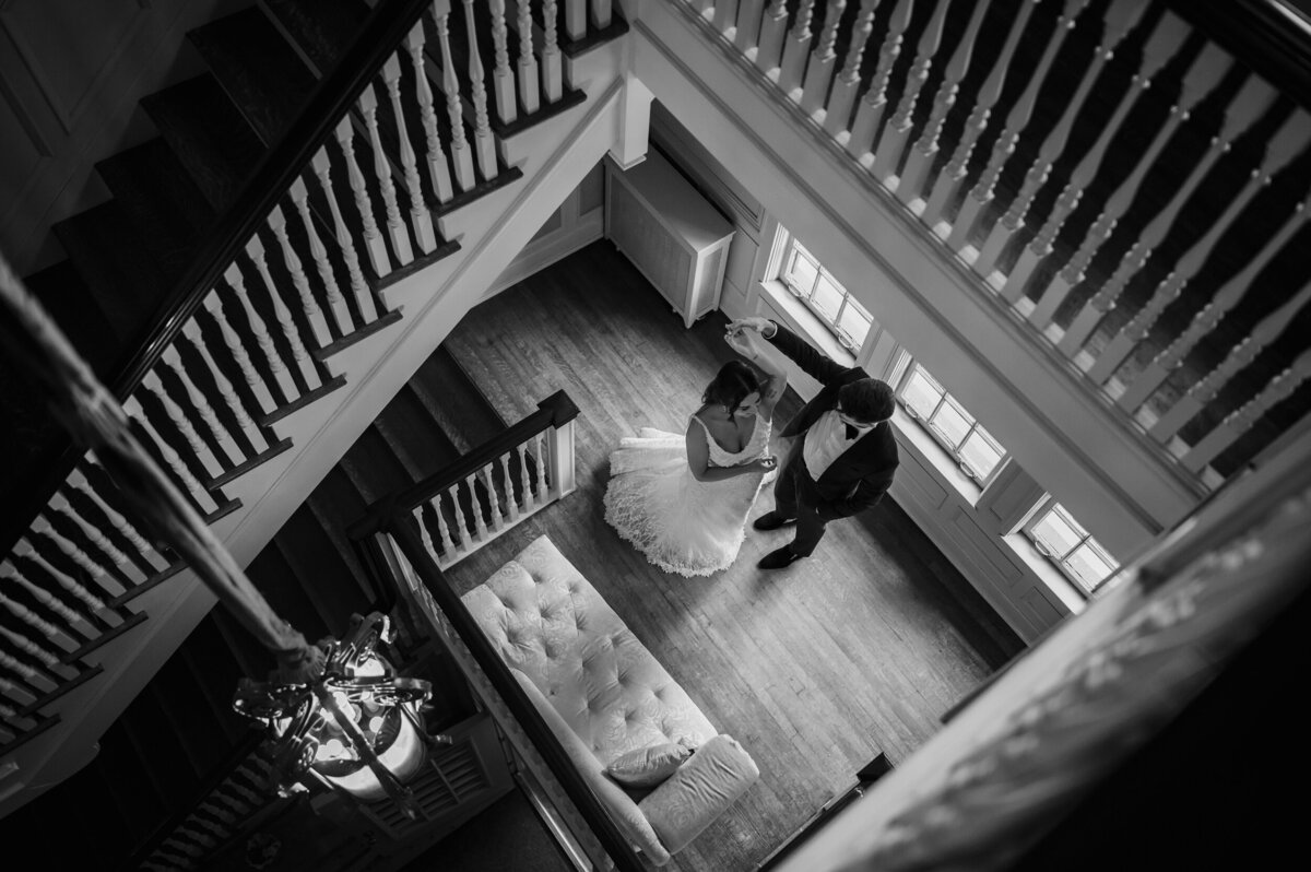 Groom and bride dance on the staircase  at Cheney Mansion in Oak Park, Illinois