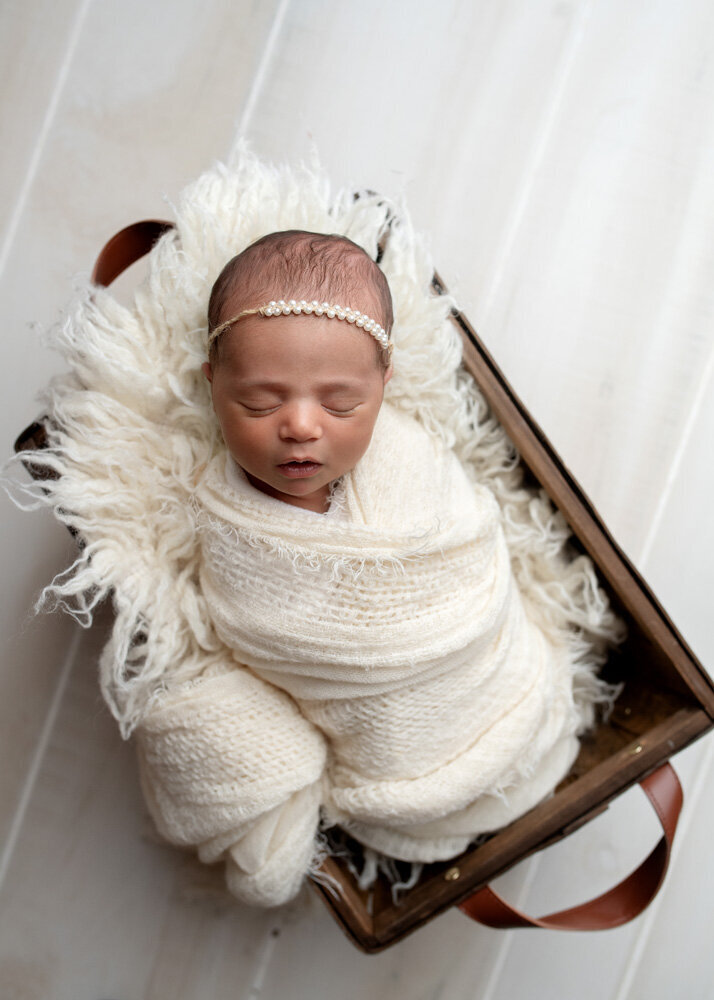 Newborn session of baby girl wearing a bow