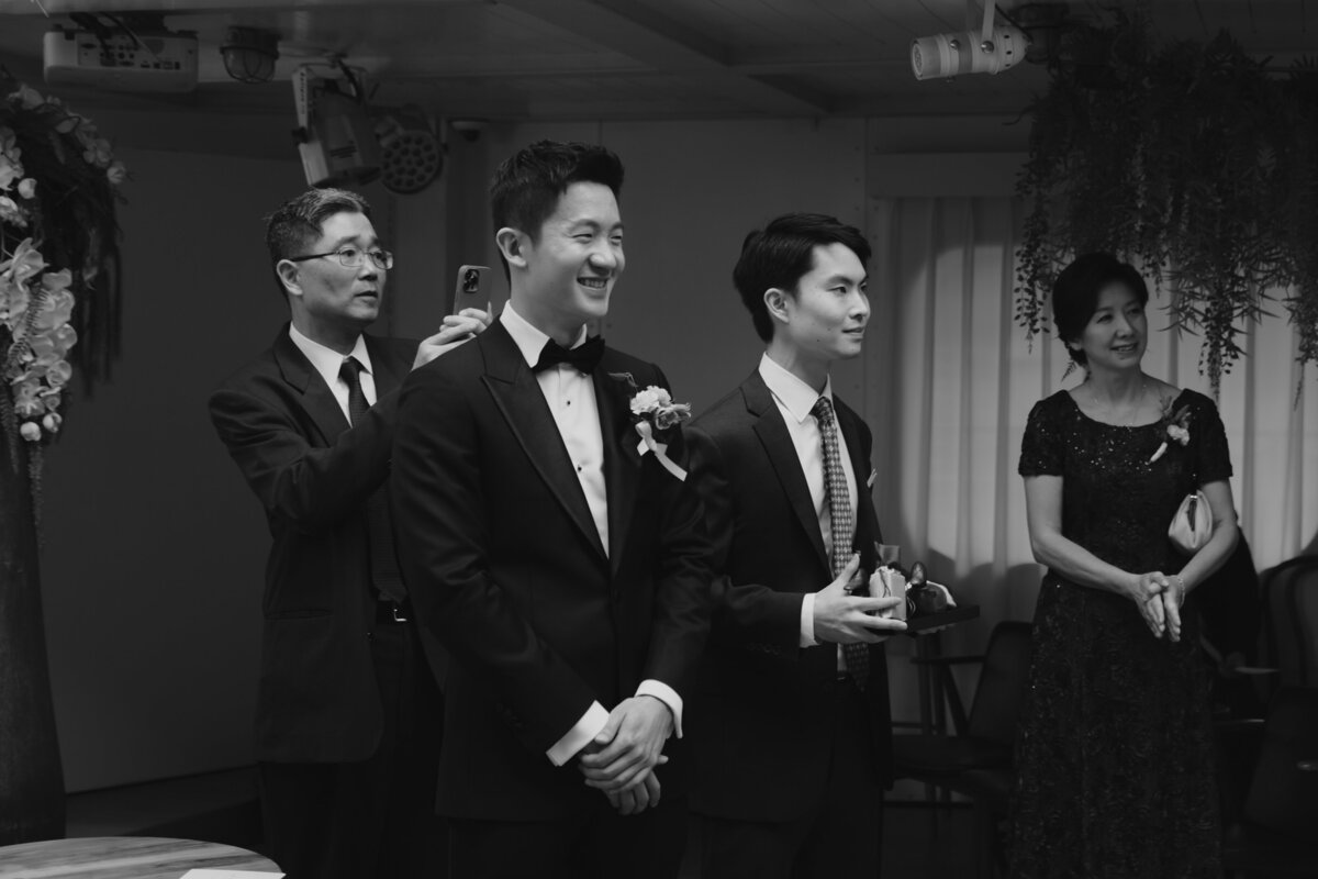 the groom smiling and waiting  while watching his bride walking down the aisle