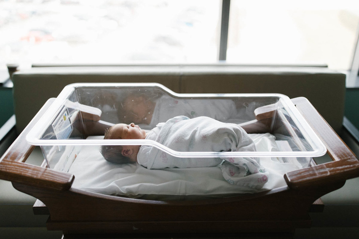 Fresh 48 session with a newborn baby boy in bassinet by Laurie Baker