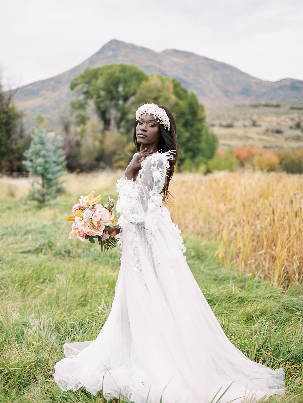 Beautiful black bride with her bouquet with a mountain background.