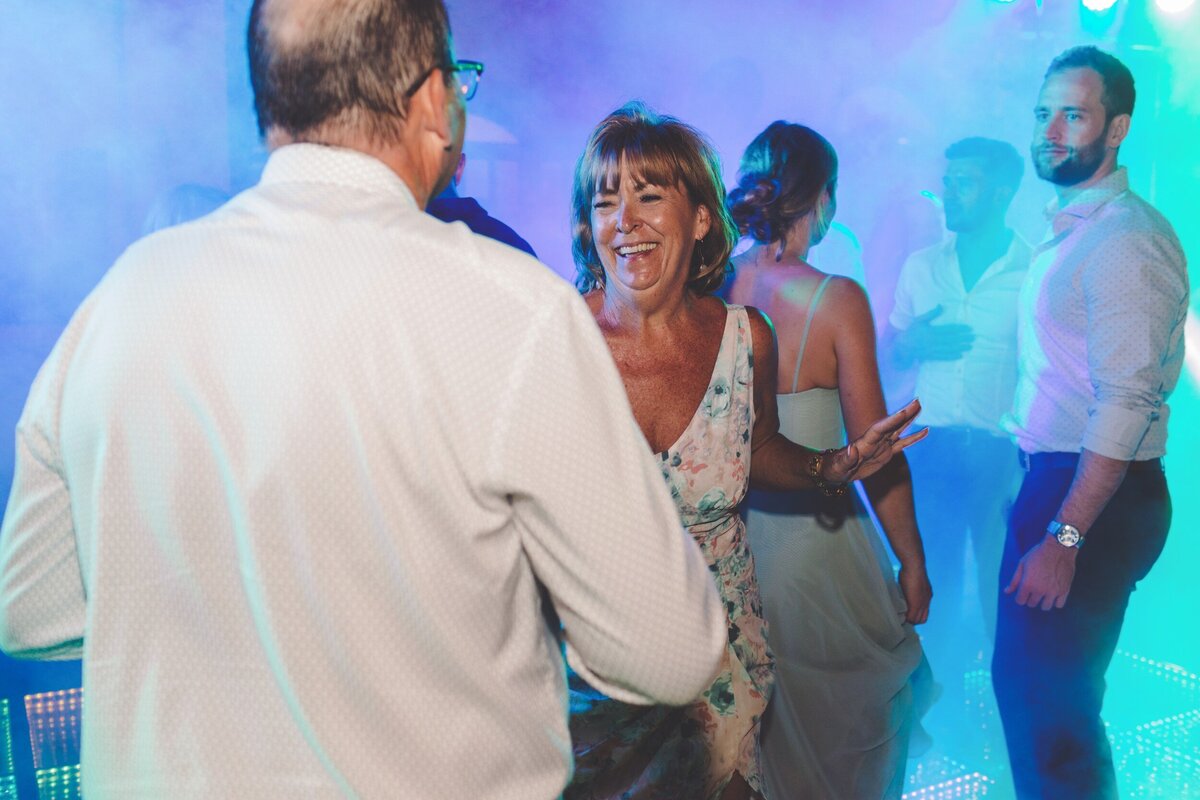 Guests dancing on dance floor at wedding