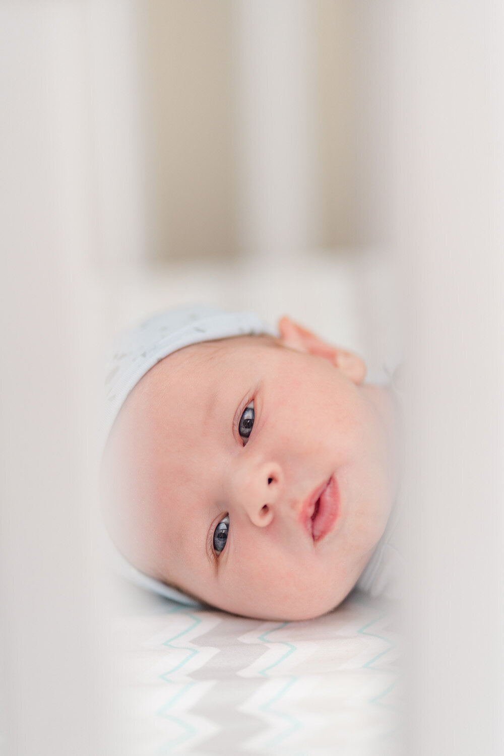 baby boy in his crib taken by a lifestyle newborn photographer in Northern Virginia