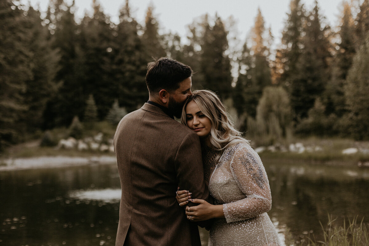 bride and groom together in front of a pond in Montana