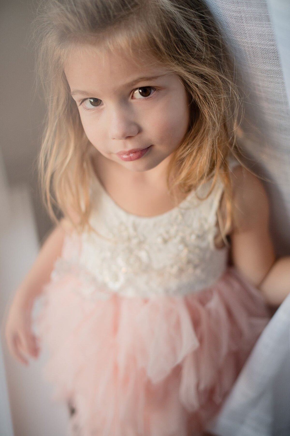 little girl in white curtain with pink tulle dress